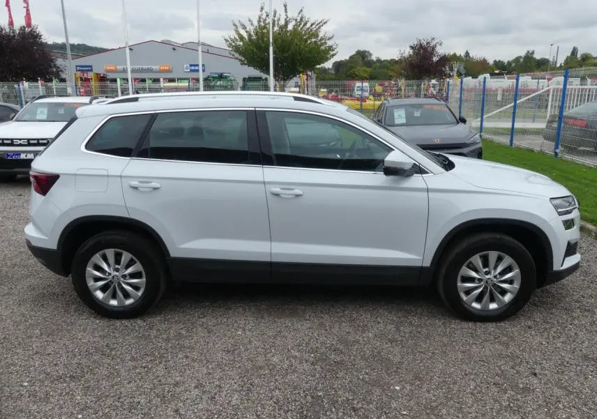Profil latéral droit d'un SUV SKODA KAROQ blanc avec jantes alliage 17'' et vitres surteintées.