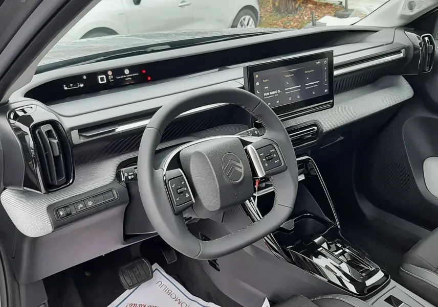 Vue intérieure côté conducteur de la Citroën C3 Aircross hybride 2025, avec tableau de bord moderne et écran tactile central.