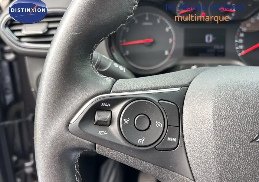 Gros plan sur le volant noir de l'Opel Crossland X 2020, mettant en valeur les commandes de régulateur de vitesse.