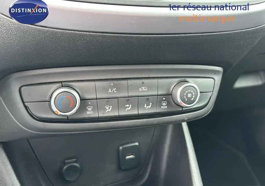 Commandes de climatisation manuelle sur tableau de bord noir de l'Opel Crossland X gris Pierre de Lune, vue de face rapprochée.