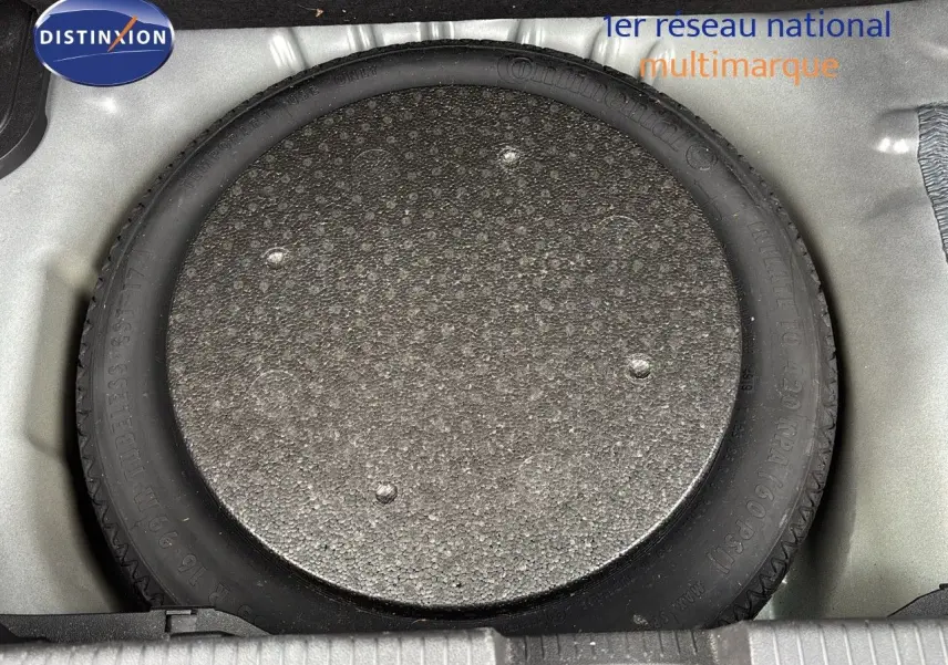 Gros plan sur la roue de secours dans le coffre d'une Opel Crossland X gris Pierre de Lune Métal.