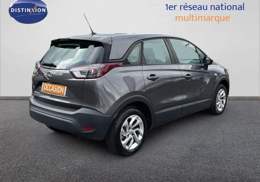Vue 3/4 arrière droite d'un Opel Crossland X gris Pierre de Lune métallisé avec toit noir et jantes argentées.