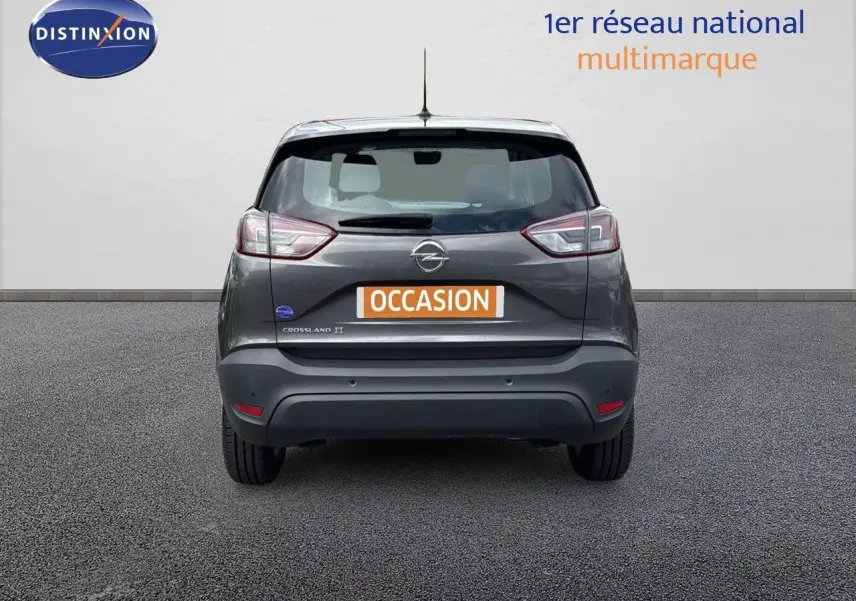 Vue arrière d'un Opel Crossland X gris pierre de lune métal avec logo et plaque d'occasion visible.