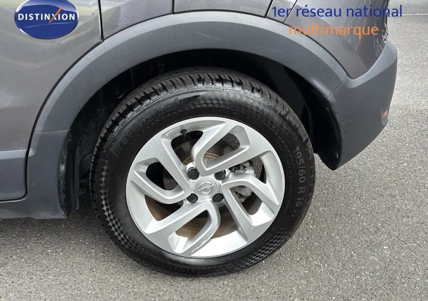 Gros plan sur la roue avant droite d'un Opel Crossland X gris Pierre de Lune métal avec jante alliage 16 pouces.