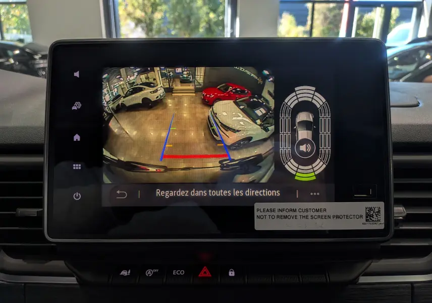 Écran tactile du système multimédia montrant la caméra de recul et les aides au stationnement du Renault Trafic Combi blanc.