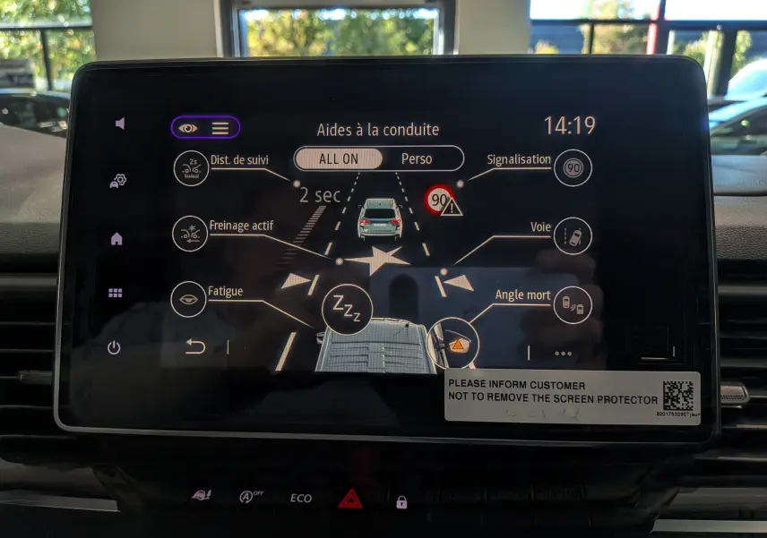 Écran tactile du tableau de bord du Renault Trafic Combi blanc, affichant les aides à la conduite en vue frontale.