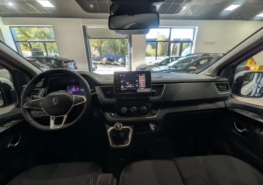 Intérieur du Renault Trafic Combi 2025, vue du poste de conduite avec tableau de bord moderne et boîte manuelle.