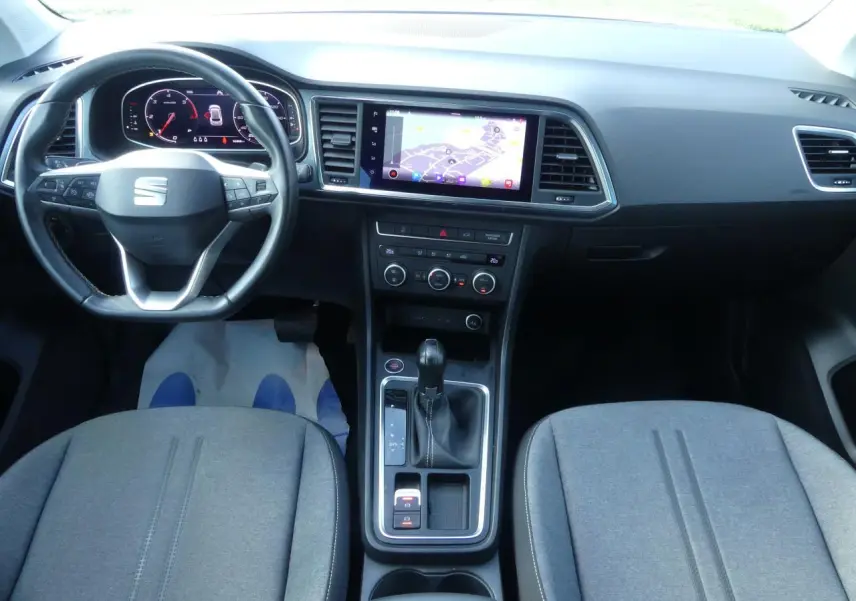 Vue intérieure avant du SEAT Ateca 2023 gris clair, avec tableau de bord numérique et écran tactile central.