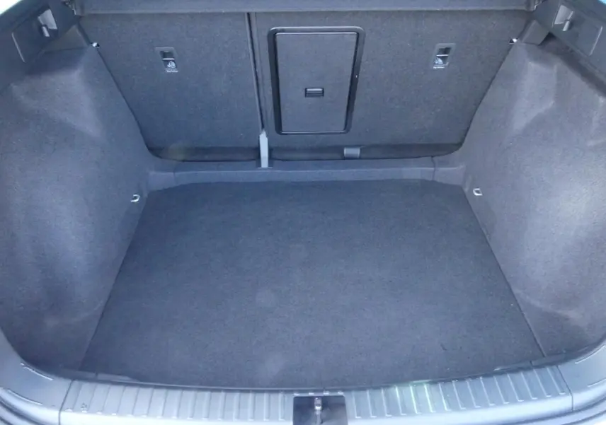 Coffre spacieux du SEAT Ateca gris clair 2023, vue intérieure arrière avec tapis et fixations ISOFIX visibles.