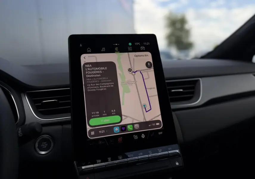 Vue intérieure centrée sur l'écran tactile vertical du tableau de bord du Renault Captur 2026, affichant la navigation.