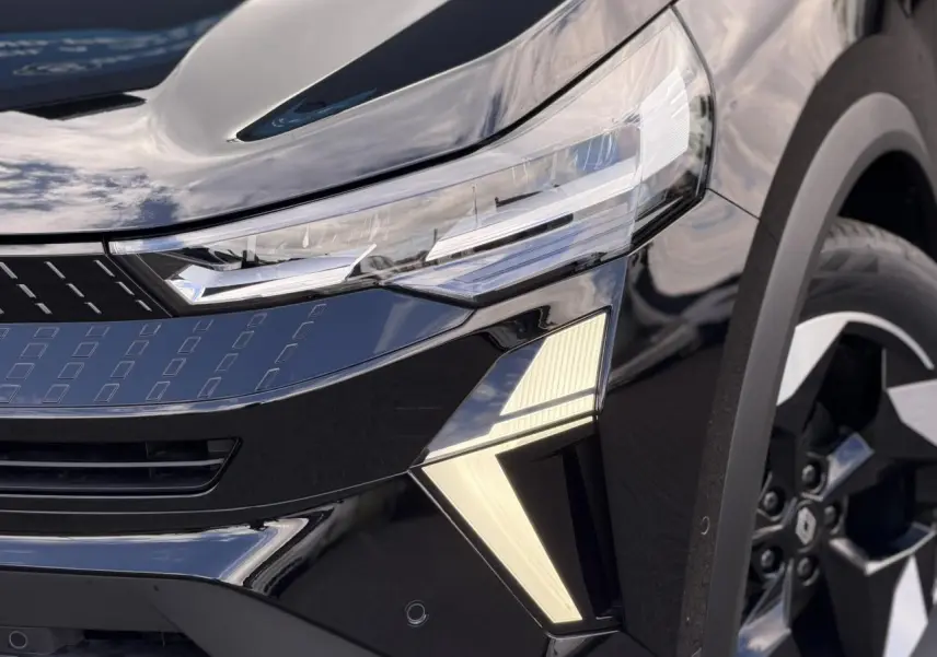 Gros plan sur l'avant droit noir étoilé du Renault Captur 2026, mettant en valeur le phare LED et la jante aluminium.