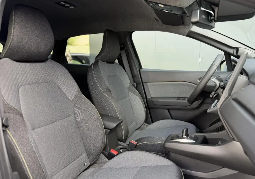 Vue intérieure côté droit du Renault Captur 2026, sièges tissu gris avec coutures jaunes et console centrale noire.
