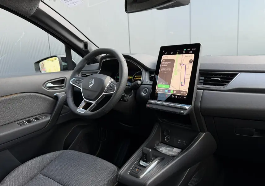 Vue intérieure côté conducteur du Renault Captur 2026 noir étoile, avec écran tactile vertical et volant multifonction.