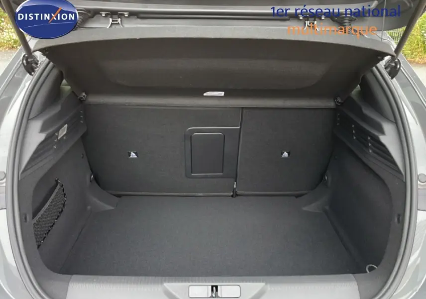 Coffre ouvert vu de l'arrière d'une Peugeot 308 gris selenium métal, espace de chargement propre et spacieux.