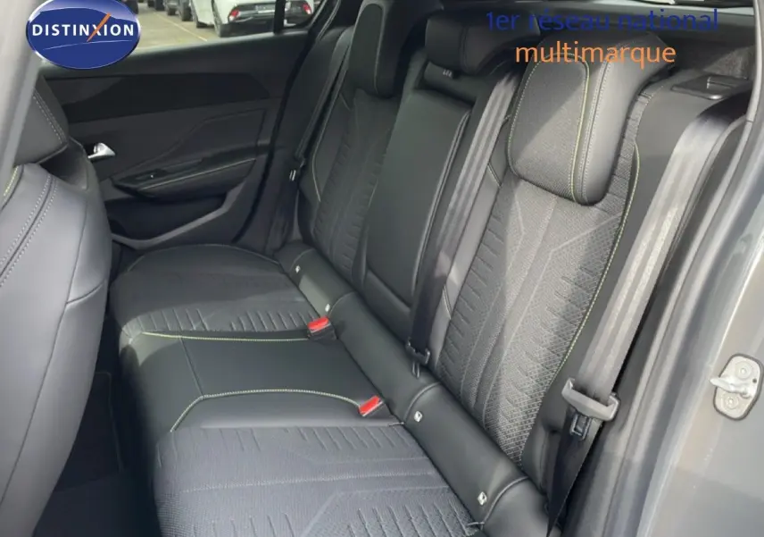 Vue intérieure côté arrière droit montrant la banquette en tissu et cuir noir avec surpiqûres vertes du Peugeot 308 gris selenium 2026.