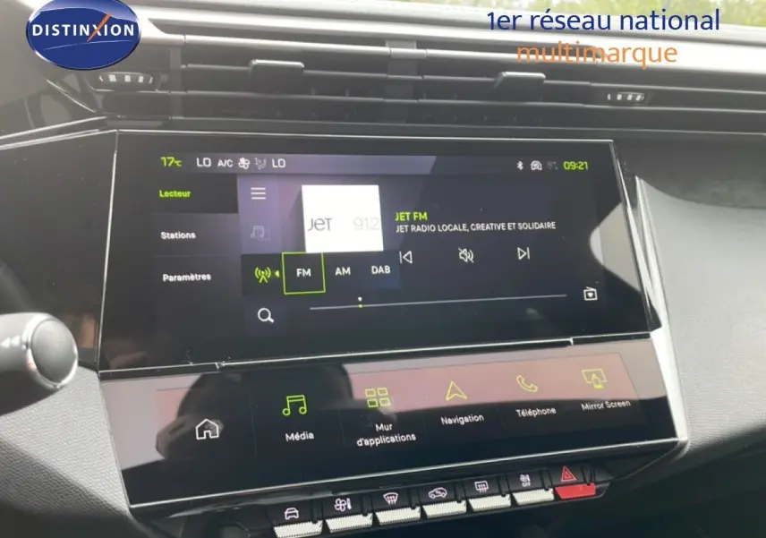 Vue rapprochée de l’écran tactile central du tableau de bord de la Peugeot 308 gris Selenium Metal, affichant la radio FM.