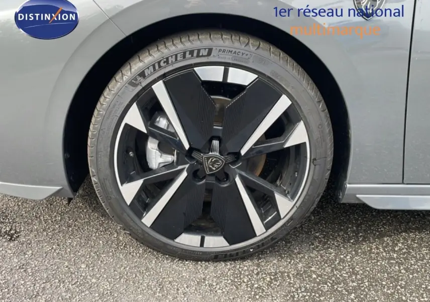 Gros plan sur la roue avant droite de la Peugeot 308 gris selenium métal avec jante noire et argentée au design moderne.