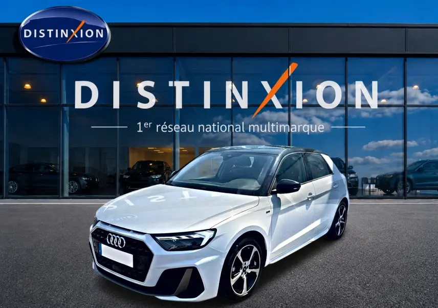 Audi A1 Sportback blanc et noir vue 3/4 avant droit devant une vitrine Distinxion, jantes alu et toit noir contrasté.