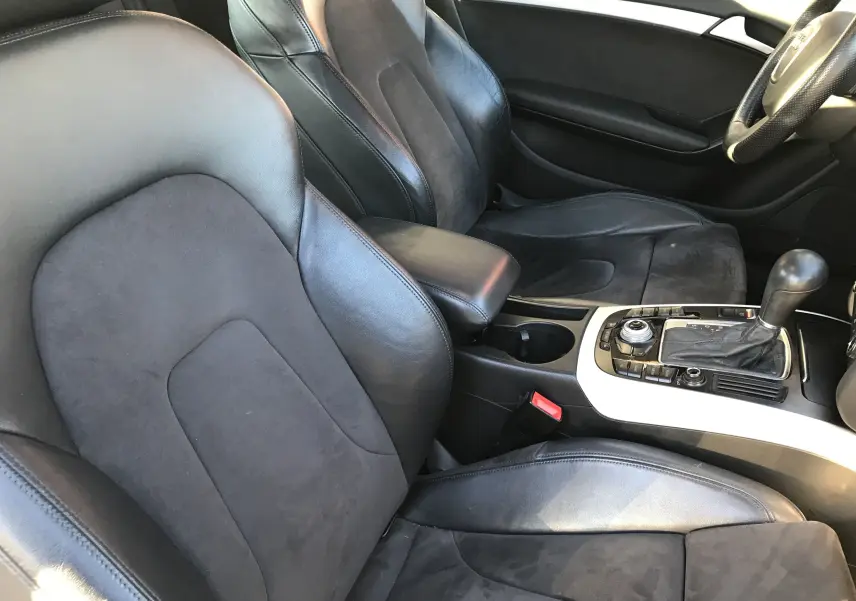 Intérieur noir cuir et alcantara de l'Audi A5 Coupé 2012, vue sur les sièges avant et la console centrale.