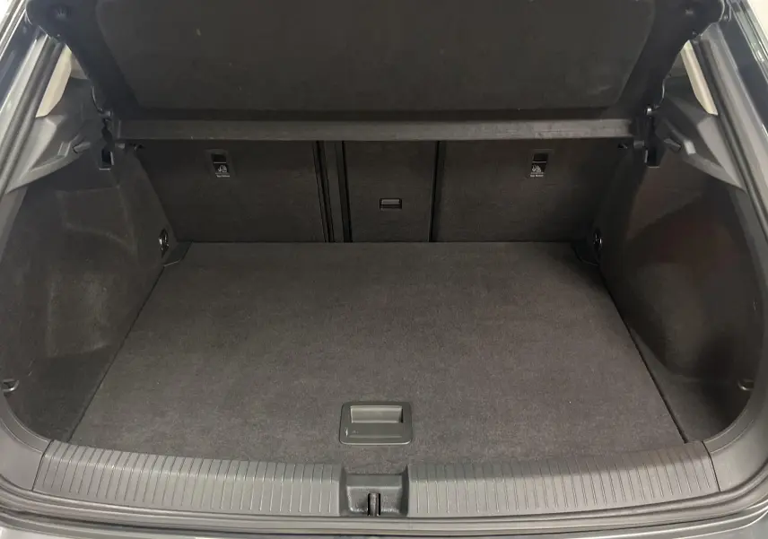 Coffre ouvert du Volkswagen T-Roc gris Indium 2024, montrant un espace de chargement propre et spacieux.