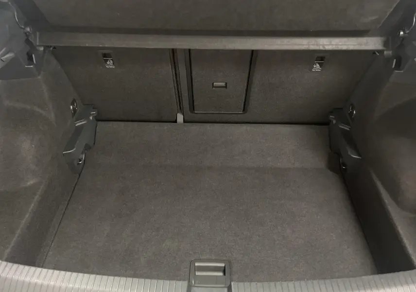 Coffre ouvert du Volkswagen T-Roc gris Indium 2024, montrant un espace de chargement propre et bien agencé.