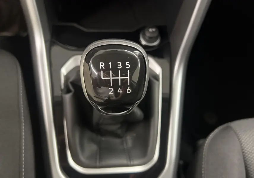 Le levier de vitesses manuel noir du Volkswagen T-Roc 2024, version 1.0 TSI 110 BVM6 LIFE, vu de dessus.