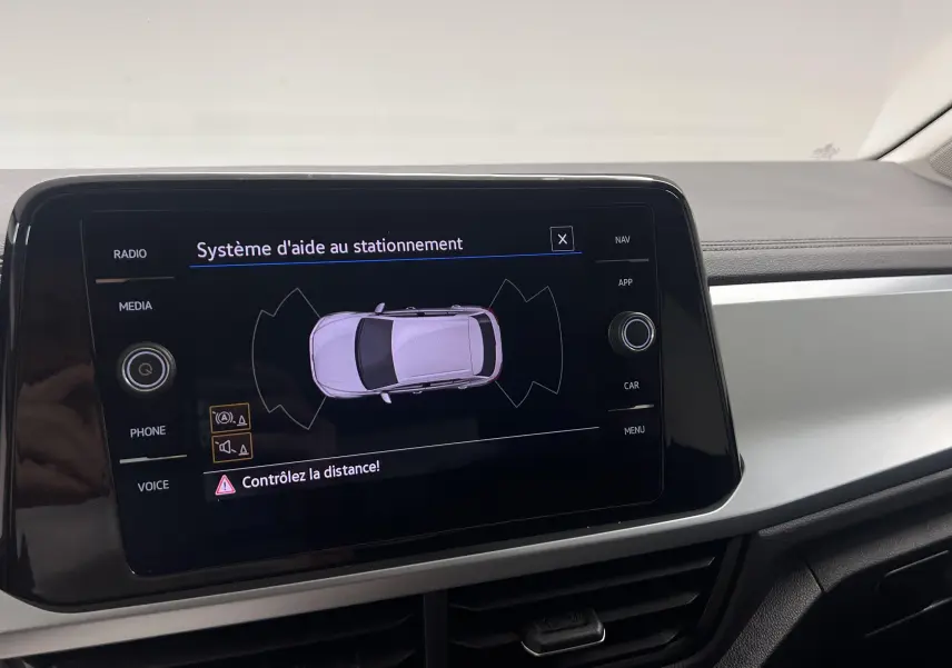 Écran central du Volkswagen T-Roc 2024 montrant le système d'aide au stationnement avec vue du véhicule en plan supérieur.