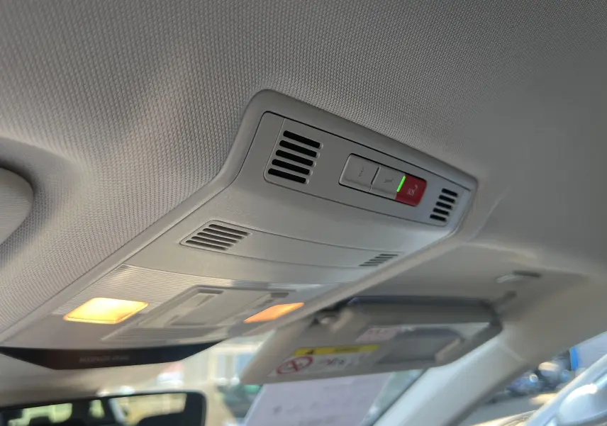 Vue intérieure du plafonnier avant du Volkswagen T-Roc 2024, avec éclairage et commandes SOS visibles.