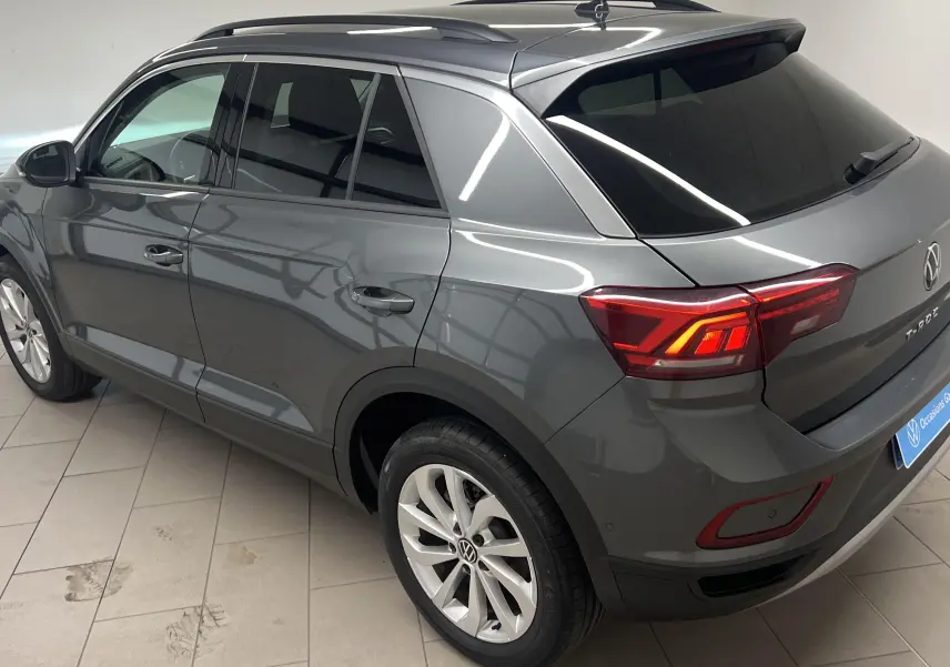 Volkswagen T-Roc gris Indium vu en 3/4 arrière droit, avec jantes alliage léger 17'' Johannesburg et vitres teintées.