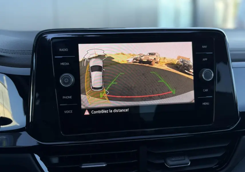 Écran central affichant la caméra de recul et l'alerte de distance du Volkswagen T-Roc 2.0 TDI gris Pyrite.