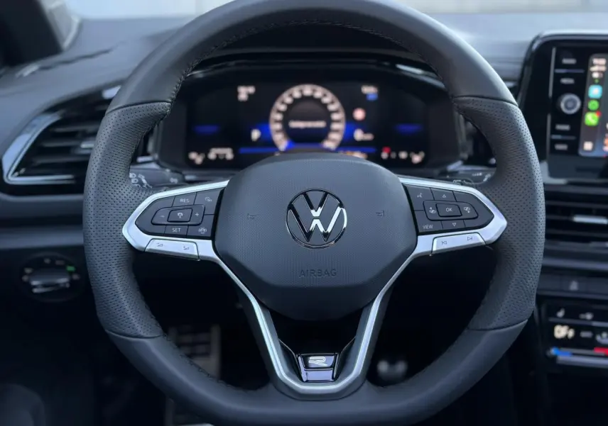 Volant sport en cuir noir avec logo VW et commandes multifonctions, vue frontale intérieure du Volkswagen T-Roc 2025.