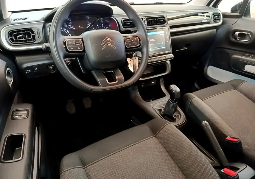 Vue intérieure avant de la Citroën C3 2019 avec tableau de bord noir, volant multifonctions et écran tactile central.