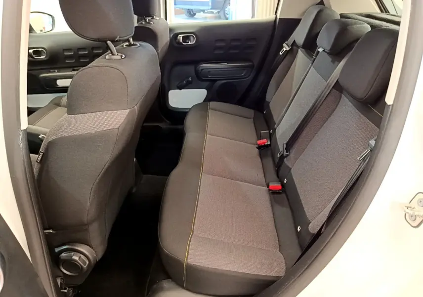 Vue intérieure côté droit sur la banquette arrière grise et noire de la Citroën C3 PureTech 82 blanche de 2019.