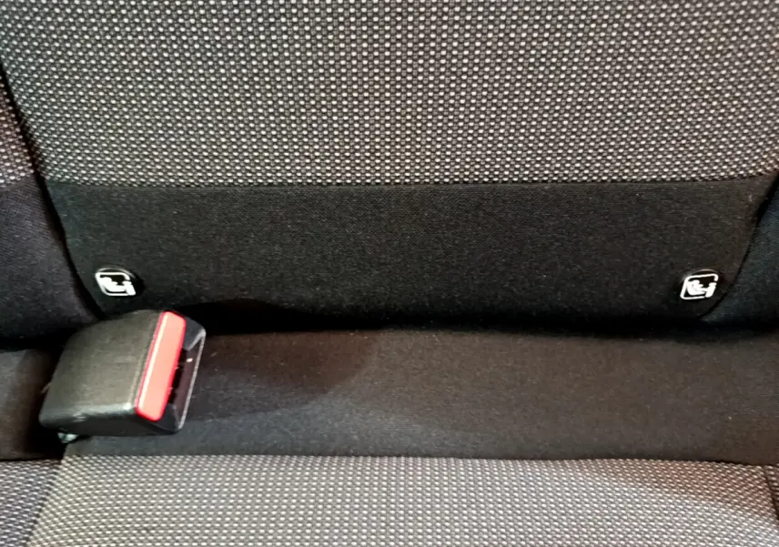 Détail de la banquette arrière noire et grise avec fixation Isofix et boucle de ceinture sur Citroën C3 blanche.