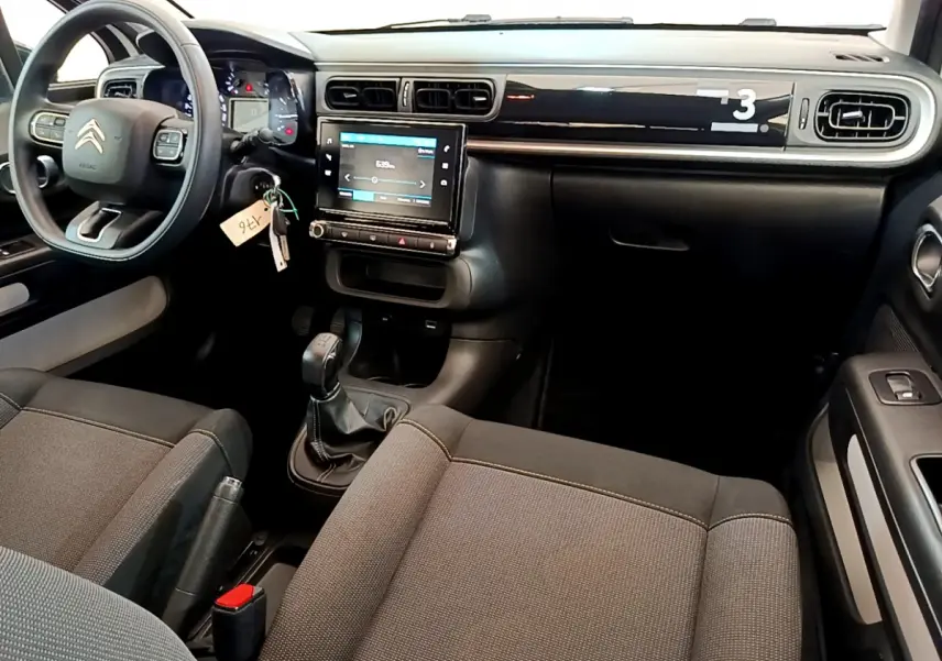 Intérieur de la Citroën C3 PureTech 82 2019 vu côté conducteur, tableau de bord noir avec écran tactile central.