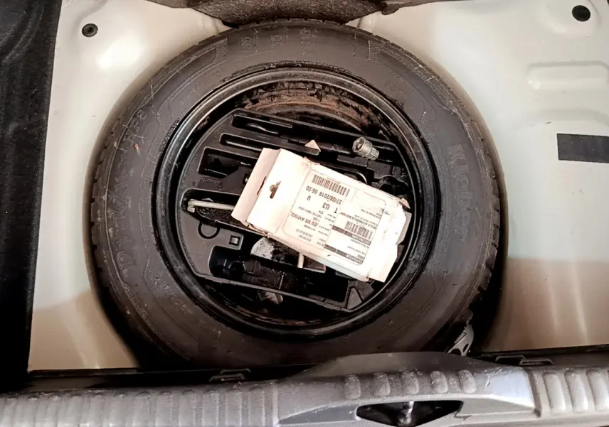 Gros plan sur la roue de secours noire dans le coffre blanc d'une Citroën C3 PureTech 82 S&S BVM Graphic 2019.