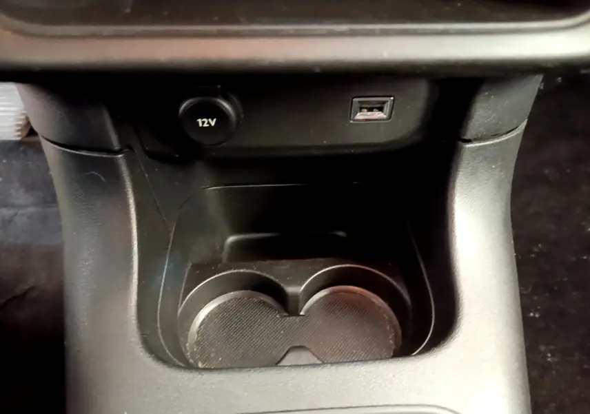 Gros plan sur la console centrale noire de la Citroën C3 avec prise 12V et port USB visibles.
