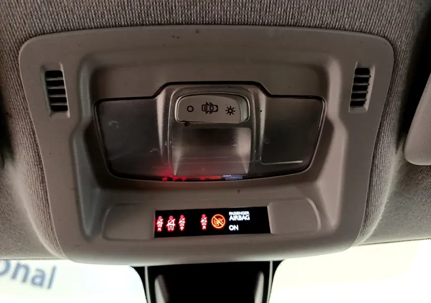 Panneau de contrôle intérieur au plafond de la Citroën C3 blanche, avec voyants de ceinture et airbag passager allumés.