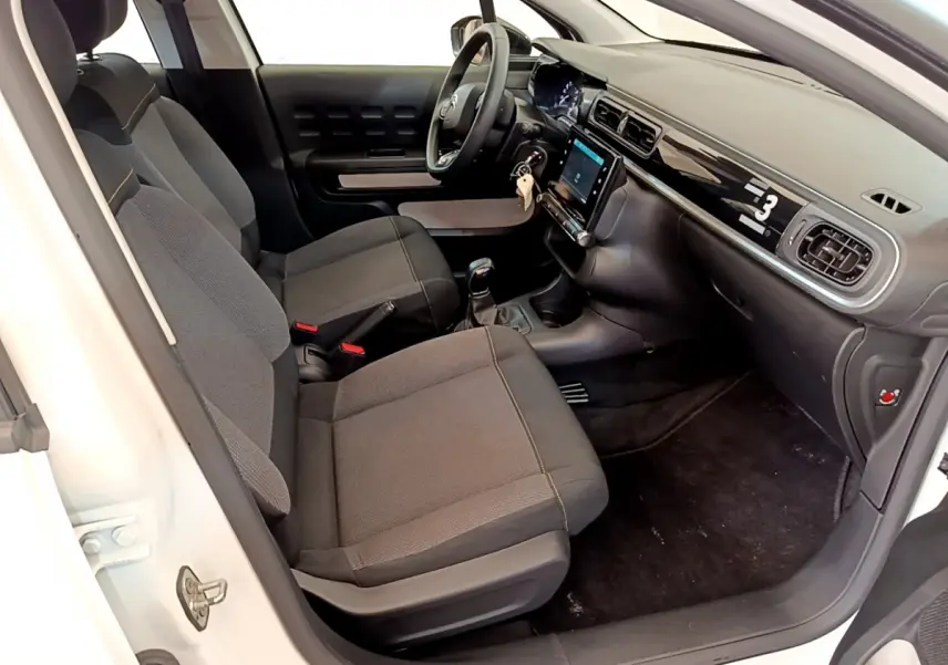 Vue intérieure côté conducteur de la Citroën C3 blanche 2019 avec tableau de bord tactile et sièges gris.