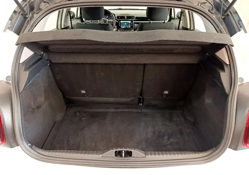 Coffre ouvert d'une Citroën C3 blanche vue de l'arrière, montrant l'espace de chargement et l'intérieur du véhicule.