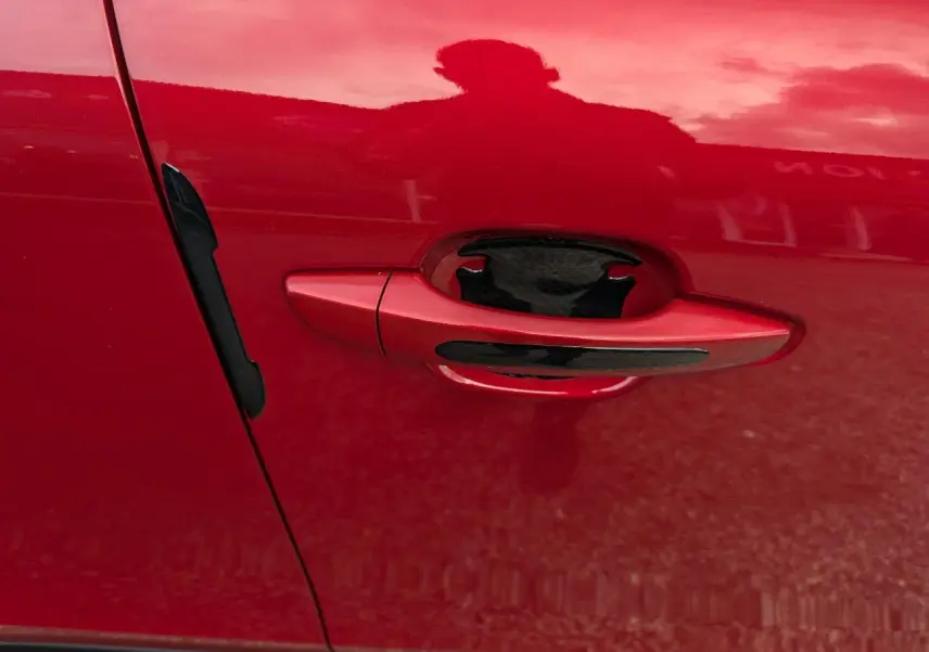 Poignée de porte côté gauche rouge foncé avec insert noir sur Citroën C4 2024 version Max.