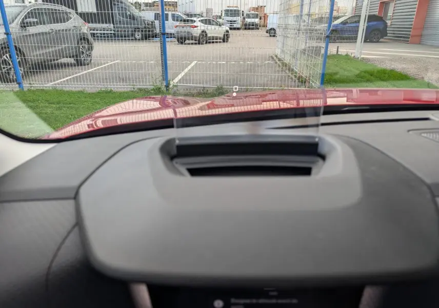 Affichage tête haute transparent sur le tableau de bord d'une Citroën C4 rouge foncé vue de l'intérieur avant.