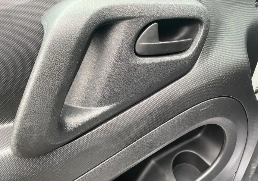 Poignée intérieure de porte côté gauche en plastique noir du Citroën Berlingo blanc, version Van M BlueHDi 2018.