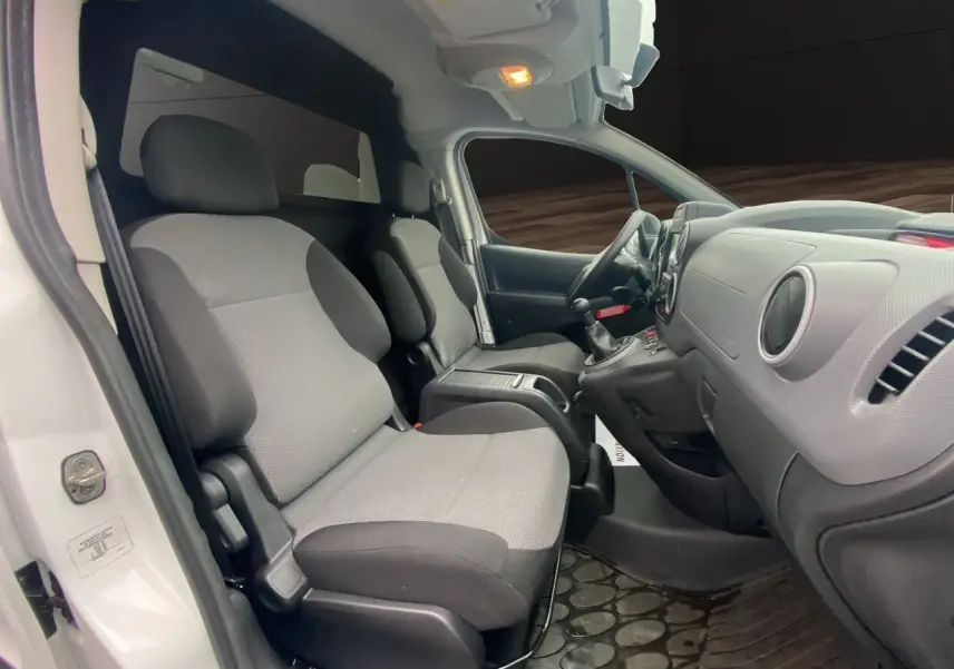 Vue intérieure côté conducteur du Citroën Berlingo blanc 2018, montrant les sièges avant et le tableau de bord.