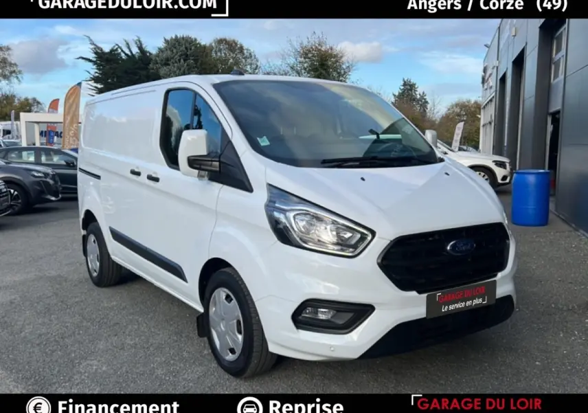 Ford Transit Custom blanc en 3/4 avant droit, fourgon utilitaire avec calandre noire et feux LED visibles.