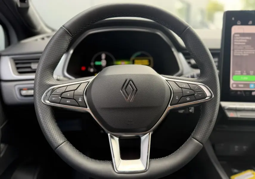 Volant en cuir noir avec commandes intégrées et logo Renault, vue frontale de l'intérieur du Renault Captur 2026.