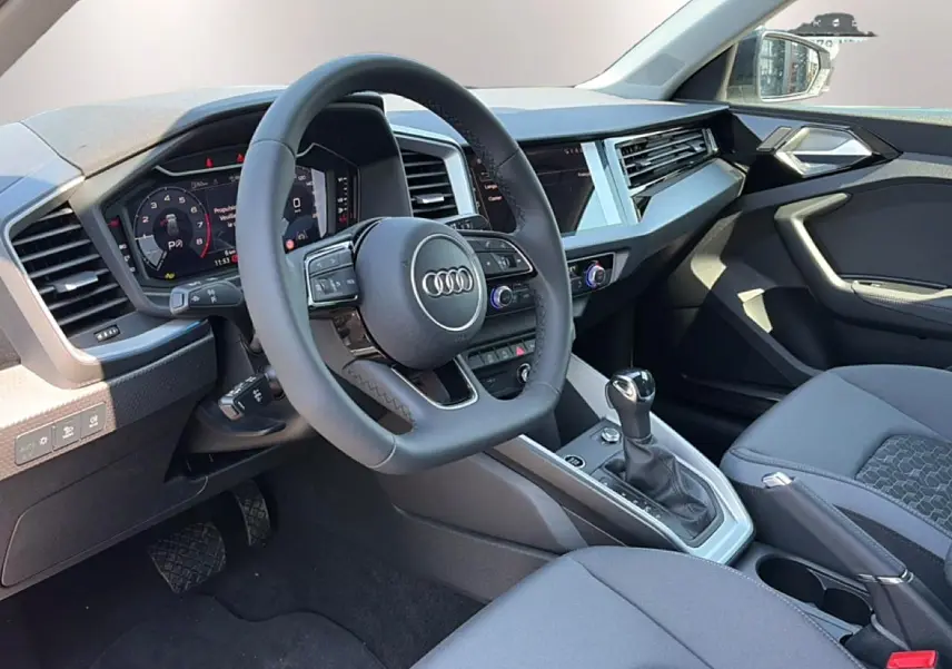 Vue intérieure côté conducteur de l’Audi A1 Sportback 30 TFSI 116 S line 2026 avec volant cuir multifonction et écran tactile.
