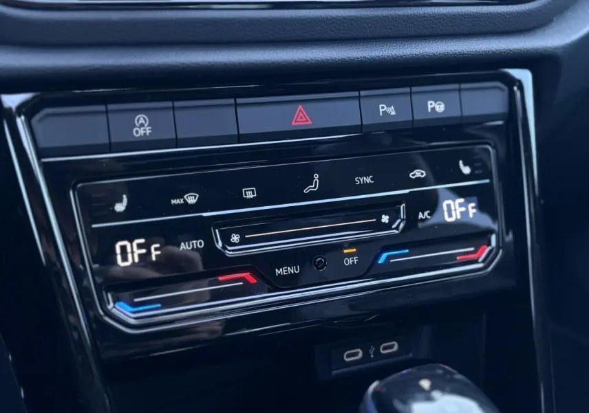 Gros plan sur la console centrale du Volkswagen T-Roc 2025 gris pyrite, affichant la climatisation automatique éteinte.