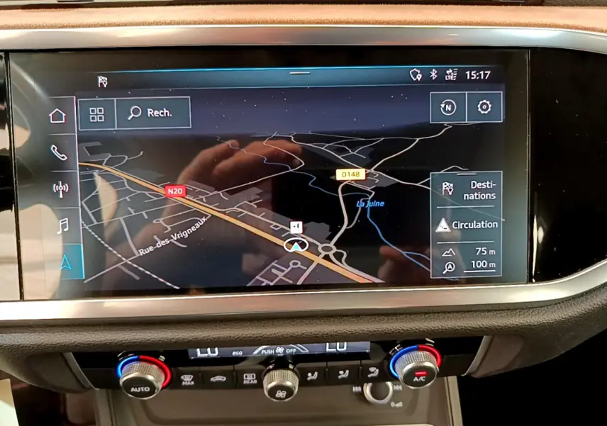 Vue rapprochée de l'écran de navigation et de la console centrale du tableau de bord de l'Audi Q3 bleu 2020.
