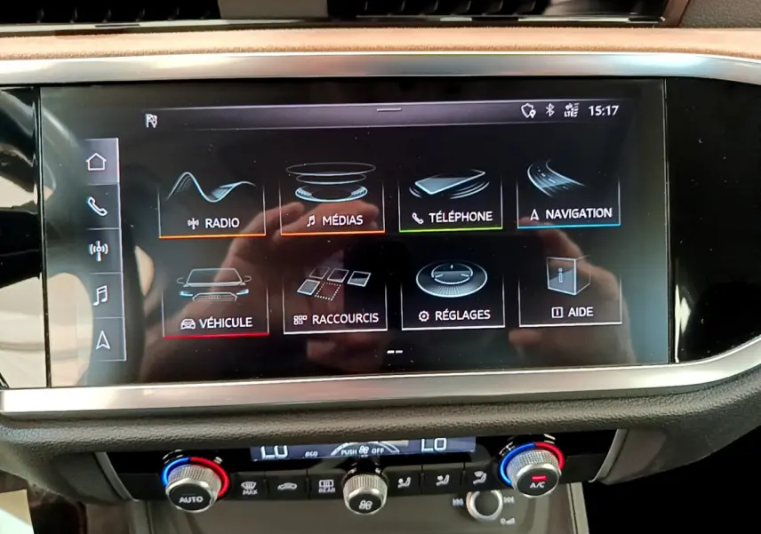 Écran tactile central affichant les menus multimédias et navigation dans l'habitacle d'un Audi Q3 35 TDI bleu.